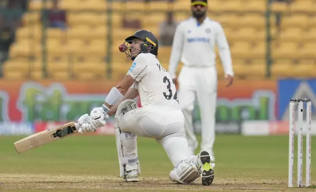 The ball hits the helmet of New Zealand's Will Young as he attempts to play a shot on a delivery by India's Ravindra Jadeja during the day five of the first cricket test match between India and New Zealand at the M.Chinnaswamy Stadium, in Bengaluru, India, Sunday, Oct. 20, 2024. (AP Photo/Aijaz Rahi)