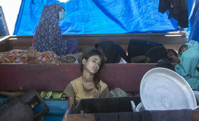 A young Rohingya girl sits on the deck of a refugee boat anchored in the waters near the coast of Labuhan Haji, Aceh province, Indonesia, Tuesday, Oct. 22, 2024. (AP Photo/Binsar Bakkara)