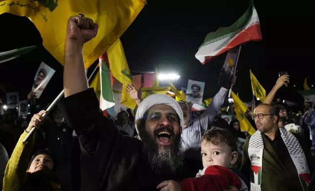 A cleric clenches his fist as he celebrates Iran's missile strike against Israel in an anti-Israeli gathering at Felestin (Palestine) Sq. in Tehran, Iran, Tuesday, Oct. 1, 2024. (AP Photo/Vahid Salemi)