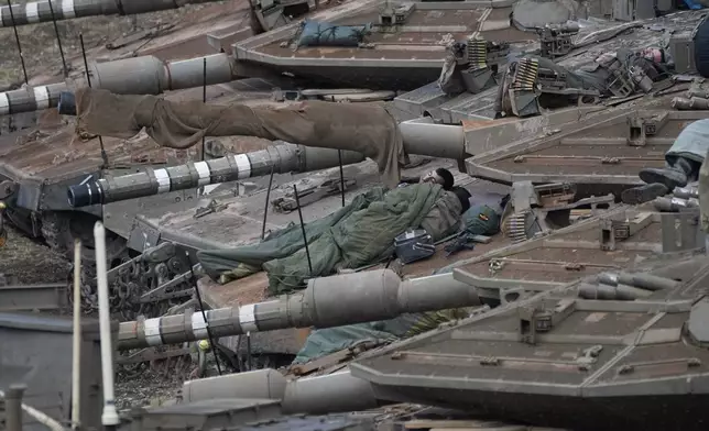 Israeli soldiers sleep on tanks in a staging area in northern Israel near the Israel-Lebanon border, Tuesday, Oct. 1, 2024. (AP Photo/Baz Ratner)