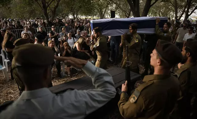 Israeli soldiers carry the flagged-covered coffin of Sgt. Amitai Alon, killed by a Hezbollah drone attack, during his funeral near Ramot Naftali, Israel, Monday, Oct. 14, 2024. (AP Photo/Leo Correa)