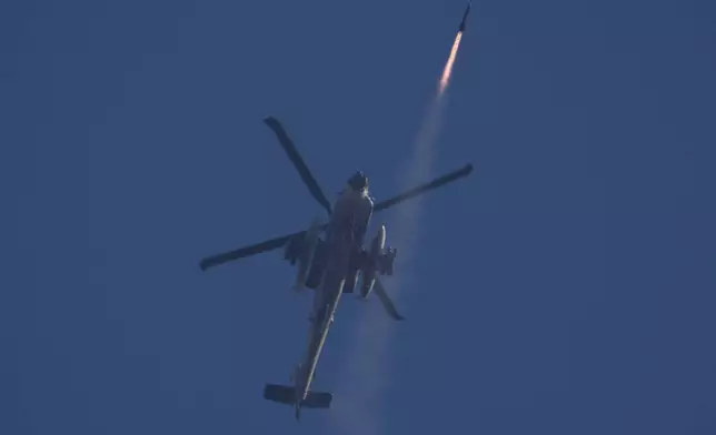 An Israeli Apache helicopter fires a missile towards southern Lebanon as seen from northern Israel, Friday, Oct. 4, 2024. (AP Photo/Leo Correa)