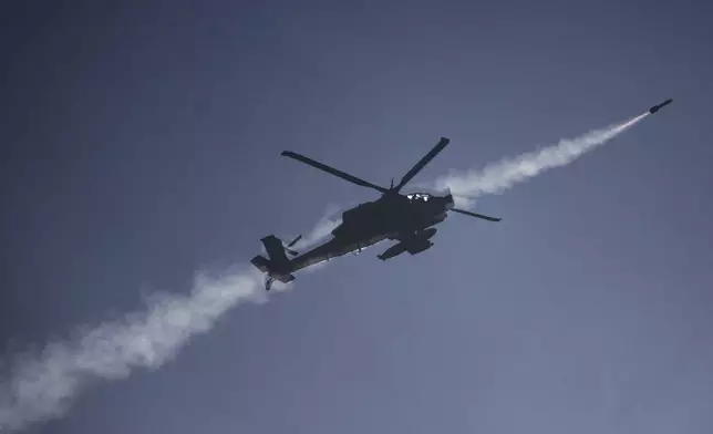 An Israeli Apache helicopter fires a missile towards southern Lebanon as seen from northern Israel, Sunday, Oct. 13, 2024. (AP Photo/Leo Correa)