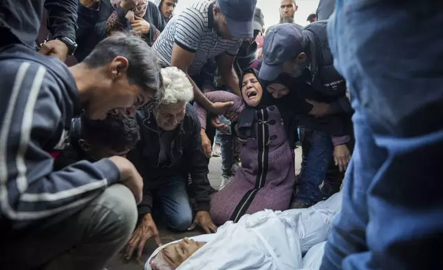 Palestinians mourn their relatives killed in the Israeli bombardment of the Gaza Strip at a hospital morgue in Deir al-Balah, Tuesday, Oct. 29, 2024. (AP Photo/Abdel Kareem Hana)