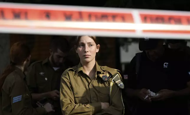 An Israeli soldier looks at the scene of a stabbing and shooting attack where Israel's Magen David Adom rescue service said one person was killed and several others were wounded in Beersheba, Israel, Sunday, Oct. 6, 2024. (AP Photo/Tsafrir Abayov)