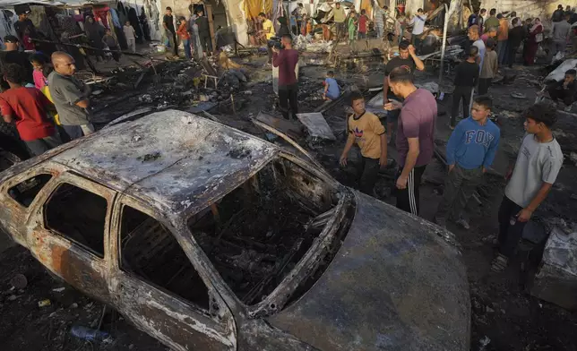 Palestinians look at the damage after an Israeli strike hit a tent area in the courtyard of Al Aqsa Martyrs hospital in Deir al Balah, Gaza Strip, Monday, Oct. 14, 2024. (AP Photo/Abdel Kareem Hana)