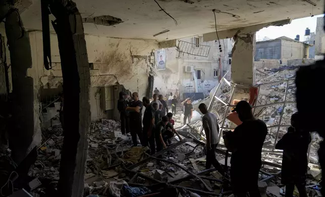 Palestinians examine the damage following an Israeli airstrike in the West Bank city of Tulkarem, which Palestinian health officials say killed 18 people and the Israeli military says took out a Hamas leader, on Friday, Oct. 4, 2024. (AP Photo/Nasser Nasser)