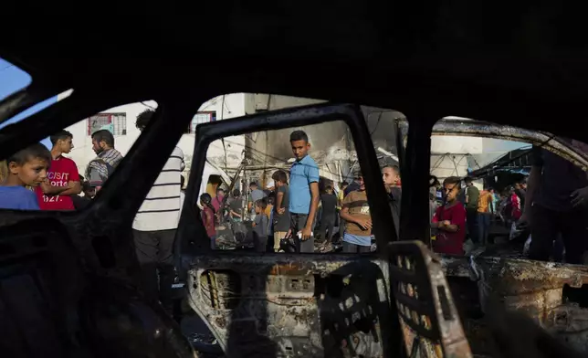 Palestinians look at the damage after an Israeli strike hit a tent area in the courtyard of Al Aqsa Martyrs hospital in Deir al Balah, Gaza Strip, Monday, Oct. 14, 2024. (AP Photo/Abdel Kareem Hana)