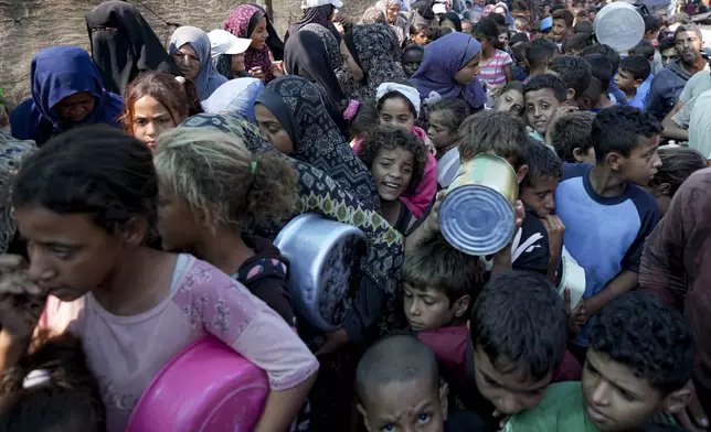 Palestinians line up for food distribution in Deir al-Balah, Gaza Strip, Thursday, Oct. 17, 2024. (AP Photo/Abdel Kareem Hana)