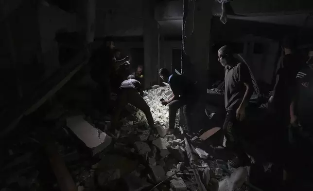 Palestinians search for survivors and bodies in the rubble of a mosque destroyed in an Israeli airstrike in Deir al-Balah, Sunday, Oct. 6, 2024. (AP Photo/Abdel Kareem Hana)