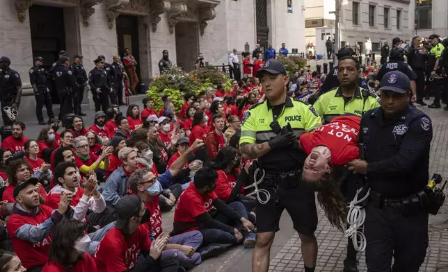 Police officers detain a demonstrator protesting Israel's war against Hamas as they occupy an area outside the New York Stock Exchange, Monday, Oct. 14, 2024, in New York. (AP Photo/Yuki Iwamura)