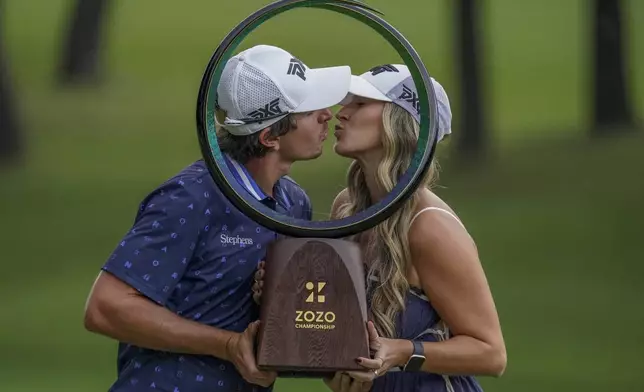 Nico Echavarria of Colombia, left, kisses his girlfriend after winning the PGA Tour Zozo Championship at the Narashino Country Club in Inzai on the outskirts of Tokyo, Sunday, Oct. 27, 2024. (AP Photo/Tomohiro Ohsumi)