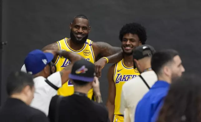 Los Angeles Lakers' LeBron James, left, and his son, Bronny James, pose for photos during the NBA basketball team's media day in El Segundo, Calif., Monday, Sept. 30, 2024. (AP Photo/Jae C. Hong)