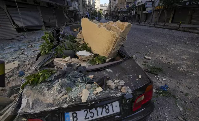 A wrecked car parked next to the site of an Israeli airstrike in Dahiyeh, Beirut, Lebanon, Thursday, Oct. 3, 2024. (AP Photo/Hassan Ammar)