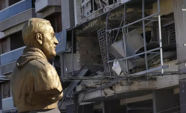 A bust of the late Iranian General Qassem Soleimani stands in front of a destroyed branch of the Hezbollah-run Qard al-Hassan, which was hit by an Israeli airstrike in Dahiyeh, Beirut, Lebanon, Monday, Oct. 21, 2024. (AP Photo/Hussein Malla)