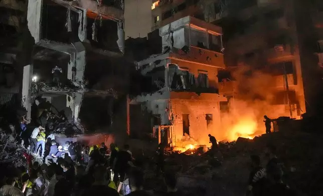 People gather in front of destroyed buildings hit by an Israeli airstrike in central Beirut, Lebanon, Thursday, Oct. 10, 2024. (AP Photo/Bilal Hussein)