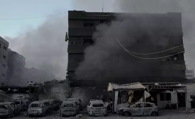 Smoke rises near charred cars at the site of an Israeli airstrike in Dahiyeh, Beirut, Lebanon, Sunday, Oct. 6, 2024. (AP Photo/Bilal Hussein)