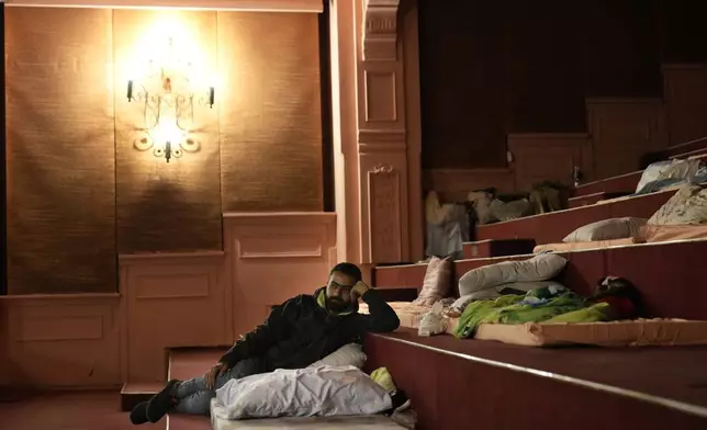 Adulkader Kurdi, who fled the ongoing Hezbollah-Israel war in south Lebanon, lies on a mattress inside one of Beirut's oldest and best known movie theatres, Le Colisee, in Beirut, Lebanon, Tuesday, Oct. 22, 2024. (AP Photo/Hussein Malla)