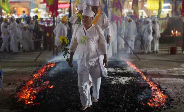 Malaysian Chinese devotees walk barefoot over burning coals during the Nine Emperor Gods festival at a temple in Kuala Lumpur, Malaysia, Friday, Oct. 11, 2024. (AP Photo/Vincent Thian)