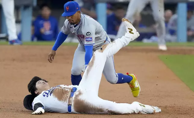 Los Angeles Dodgers' Shohei Ohtani steals second base past New York Mets shortstop Francisco Lindor during the second inning in Game 1 of a baseball NL Championship Series, Sunday, Oct. 13, 2024, in Los Angeles. (AP Photo/Mark J. Terrill)