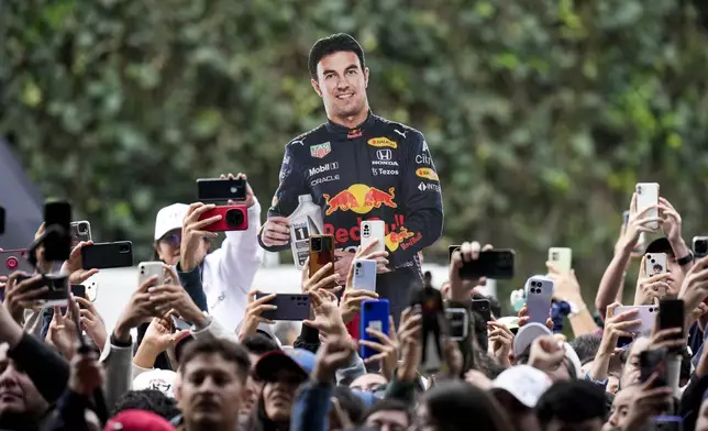 Fans of Red Bull driver Sergio Perez, from Mexico, attend a promotional event by sponsors in Mexico City, Wednesday, Oct. 23, 2024, ahead of the weekend Formula One Mexico Grand Prix auto race. (AP Photo/Moises Castillo)