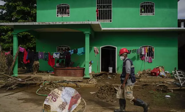 A volunteer inspects the damage in Coyuca de Benitez, Guerrero state, Mexico, after Hurricane John passed through, Monday, Sept. 30, 2024. (AP Photo/Felix Marquez)