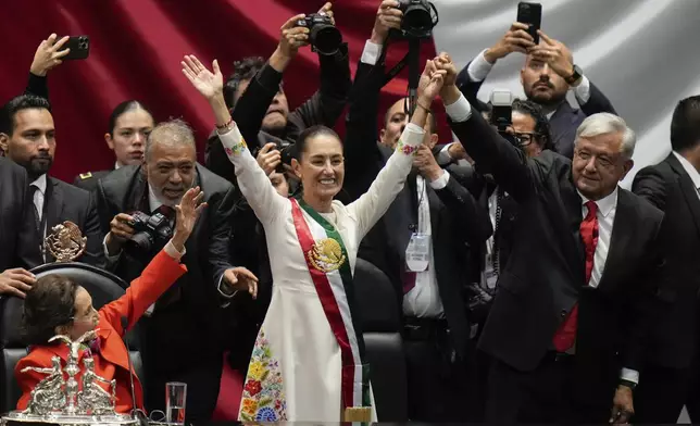 President Claudia Sheinbaum, center, and outgoing President Andres Manuel López Obrador, right, stand before lawmakers on her inauguration day at Congress in Mexico City, Tuesday, Oct. 1, 2024. (AP Photo/Eduardo Verdugo)