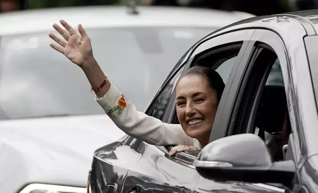 Claudia Sheinbaum waves from the vehicle taking her to Congress to be sworn in as president in Mexico City, Tuesday, Oct. 1, 2024. (AP Photo/Aurea Del Rosario)