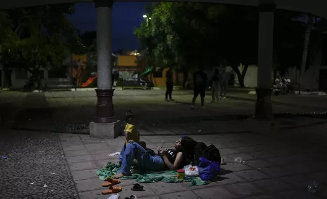 Afghan migrant Khatera Mohammedi and her son Kein camp out in a public square in Tapachula, Mexico, Sunday, Oct. 27, 2024. (AP Photo/Matias Delacroix)