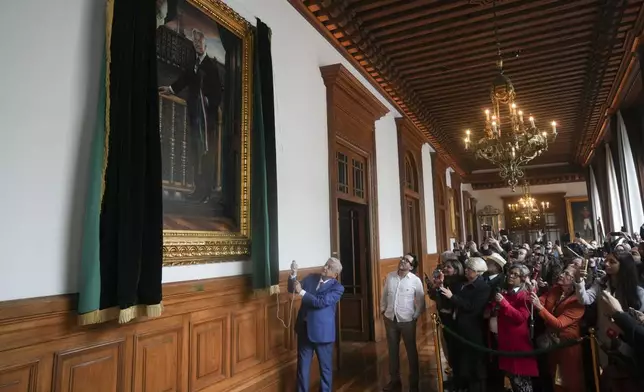 Mexican President Andres Manuel Lopez Obrador unveils his portrait at the National Palace after giving his last morning press conference, "La Mañanera," in Mexico City, Monday, Sept. 30, 2024. (AP Photo/Fernando Llano)