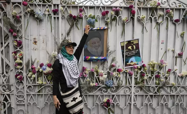 A woman shouts slogans with a painting of late Hezbollah leader Hassan Nasrallah in front of the Lebanese Embassy during a pro-Palestinian rally in Bogota, Colombia, Monday, Oct. 7, 2024. (AP Photo/Fernando Vergara)