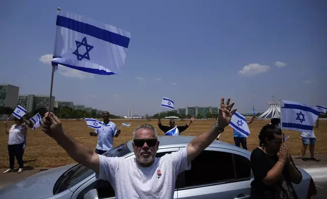 People pray during a pro-Israel demonstration to mark the first anniversary of the Hamas attack on Israel, in Brasilia, Brazil, Sunday, Oct. 6, 2024. (AP Photo/Eraldo Peres)