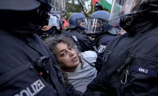 Police officers detain a demonstrator during a pro-Palestinian rally in Berlin, Monday, Oct. 7, 2024. (AP Photo/ Ebrahim Noroozi)