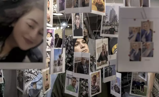 A woman views photos of Palestinian victims who were killed during the Israel war against Hamas, at a photo exhibition, (Gaza Habibti), Gaza my love, to commemorate the one-year anniversary of the war in the Gaza Strip, in Cairo, Egypt, Monday, Oct. 7, 2024. (AP Photo/Amr Nabil)