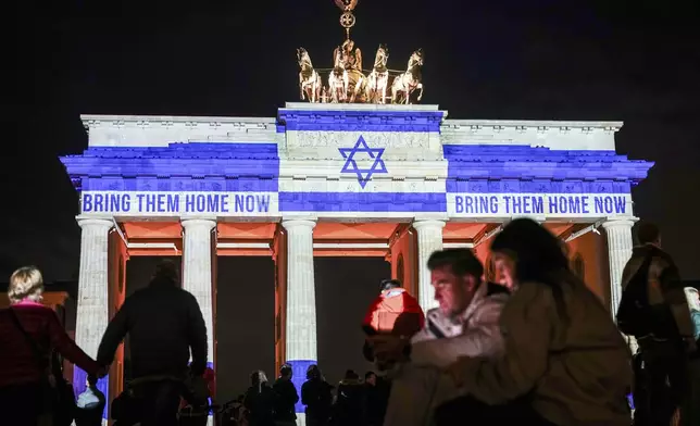 The Brandenburg Gate is illuminated with the flag of Israel in Berlin, Germany, Monday, Oct. 7, 2024, to mark the anniversary of the Hamas attack on Israel on Oct. 7, 2023. (Kay Nietfeld/dpa via AP)