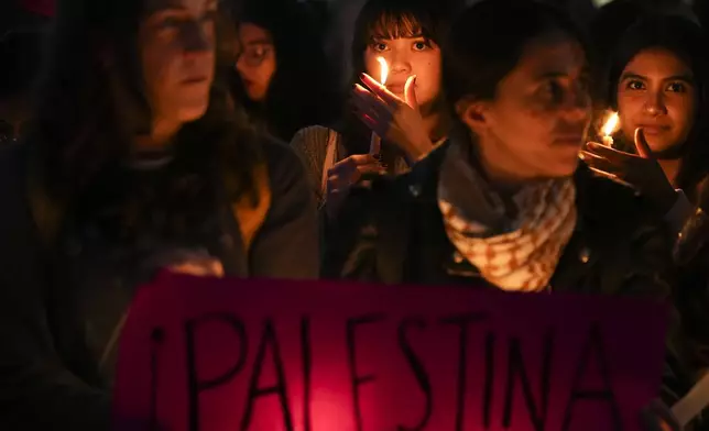 People hold candles during a vigil marking the one-year anniversary of the start of the Israel-Hamas war, in Mexico City, Monday, Oct. 7, 2024. (AP Photo/Fernando Llano)