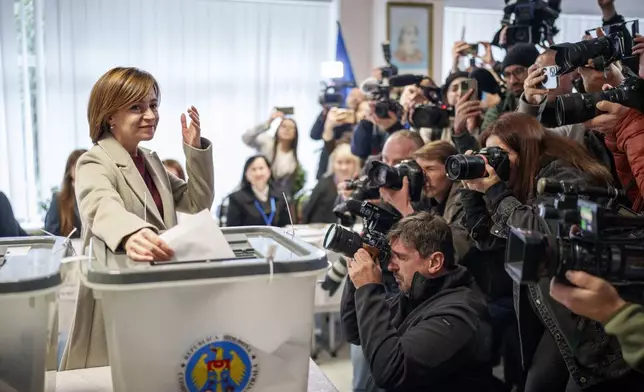 Moldova's President Maia Sandu prepares to cast her vote, in Chisinau, Moldova, Sunday, Oct. 20, 2024, during a presidential election and a referendum on whether to enshrine in the Constitution the country's path to European Union membership. (AP Photo/Vadim Ghirda)