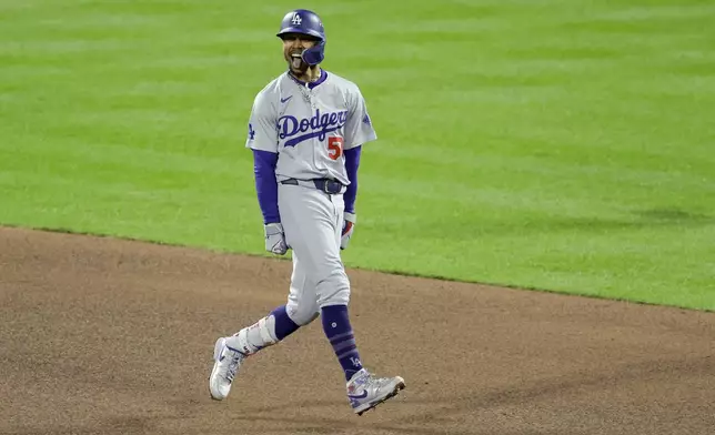 Los Angeles Dodgers' Mookie Betts celebrates after a two run double against the New York Mets during the fourth inning in Game 4 of a baseball NL Championship Series, Thursday, Oct. 17, 2024, in New York. (AP Photo/Adam Hunger)