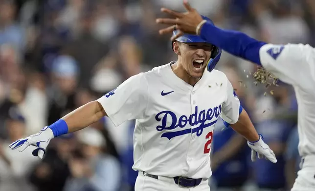 Los Angeles Dodgers' Tommy Edman celebrates a two-run home run against the New York Mets during the third inning in Game 6 of a baseball NL Championship Series, Sunday, Oct. 20, 2024, in Los Angeles. (AP Photo/Ashley Landis)