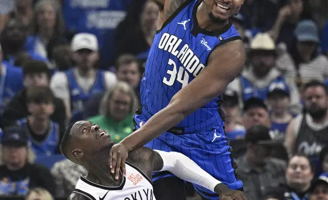 Orlando Magic center Wendell Carter Jr. (34) is fouled by Brooklyn Nets guard Dennis Schroder (17), while reaching for a lob pass during the first half of an NBA basketball game Friday, Oct. 25, 2024, in Orlando, Fla. (AP Photo/Phelan M. Ebenhack)