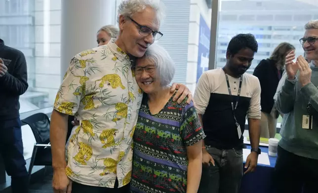 Victor Ambros, left, 2024 Nobel Prize winner in physiology or medicine, and professor of natural science at the University of Massachusetts Medical School, hugs his wife Rosalind Lee following a news conference, Monday, Oct. 7, 2024, at the school in Worcester, Mass. (AP Photo/Steven Senne)