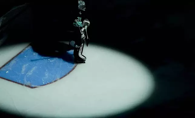 Seattle Kraken goaltender Philipp Grubauer stands near the goal as pregame spotlights flash during the first period of a preseason NHL hockey game against the Edmonton Oilers, Wednesday, Oct. 2, 2024, in Seattle. (AP Photo/Lindsey Wasson)