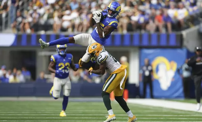 Los Angeles Rams wide receiver Demarcus Robinson (15) catches a pass over Green Bay Packers cornerback Keisean Nixon (25) during the first half of an NFL football game Sunday, Oct. 6, 2024, in Inglewood, Calif. (AP Photo/Ryan Sun)