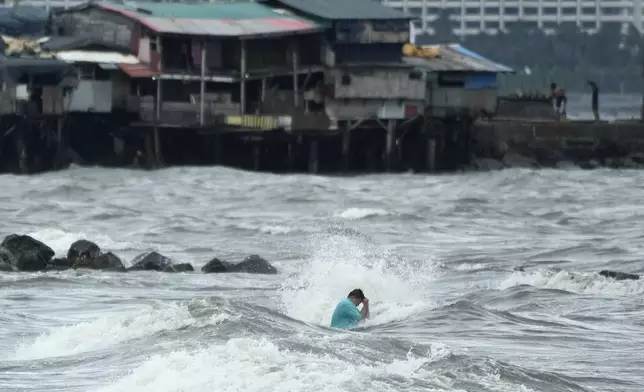 A resident swims despite the strong waves caused by Tropical Storm Trami in Manila, Philippines Wednesday, Oct. 23, 2024. (AP Photo/Aaron Favila)