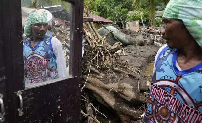 Marcelino Aringo speaks near his damaged house after a landslide triggered by Tropical Storm Trami struck homes, leaving several villagers dead in Talisay, Batangas province, Philippines on Saturday, Oct. 26, 2024. (AP Photo/Aaron Favila)