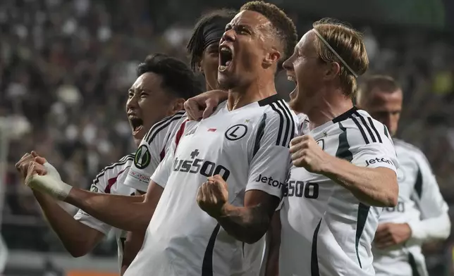 Legia Warsaw Steve Kapuadi, center, celebrates scoring his side's opening goal during the Europa League soccer match between Legia Warsaw and Real Betis in Warsaw, Poland, Thursday Oct. 3, 2024. (AP Photo/Czarek Sokolowski)