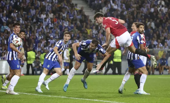 Manchester United's Harry Maguire, foreground right, scores his side's third goal during a Europa League opening phase soccer match between FC Porto and Manchester United at the Dragao stadium in Porto, Portugal, Thursday, Oct. 3, 2024. (AP Photo/Luis Vieira)