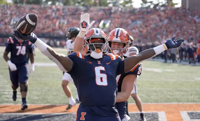 Illinois running back Josh McCray celebrates his touchdown with tight end Carson Goda during the first half of an NCAA college football game against Purdue on Saturday, Oct. 12, 2024, in Champaign, Ill. (AP Photo/Charles Rex Arbogast)