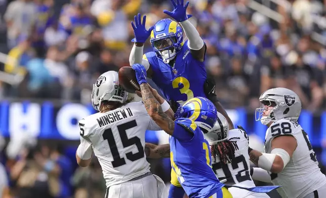 Los Angeles Rams cornerback Cobie Durant (14) forces a fumble against Las Vegas Raiders quarterback Gardner Minshew (15) as Rams safety Kamren Curl (3) jumps to defend during the first half of an NFL football game Sunday, Oct. 20, 2024, in Inglewood, Calif. (AP Photo/Ryan Sun)