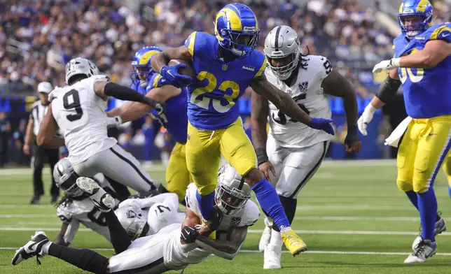 Los Angeles Rams running back Kyren Williams (23) runs for a touchdown as Las Vegas Raiders safety Isaiah Pola-Mao, bottom, attempts to tackle during the first half of an NFL football game against the Las Vegas Raiders, Sunday, Oct. 20, 2024, in Inglewood, Calif. (AP Photo/Ryan Sun)